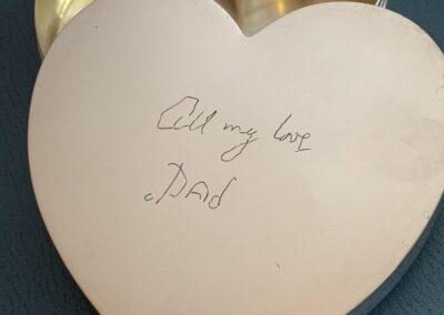 A silver heart-shaped box with a handwritten message on the lid that reads All my love, Dad—an elegant keepsake inspired by I Carry Your Heart With Me.
