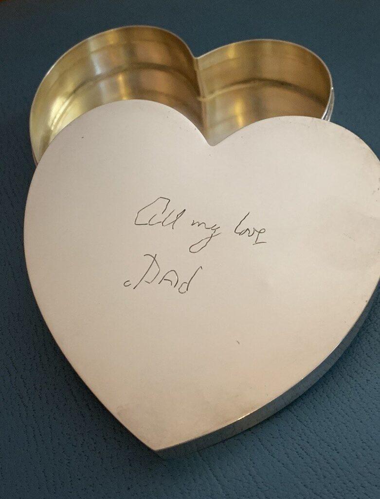 A silver heart-shaped box with a handwritten message on the lid that reads All my love, Dad—an elegant keepsake inspired by I Carry Your Heart With Me.